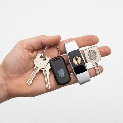Hand holding various types of keys and a modern lock cylinder